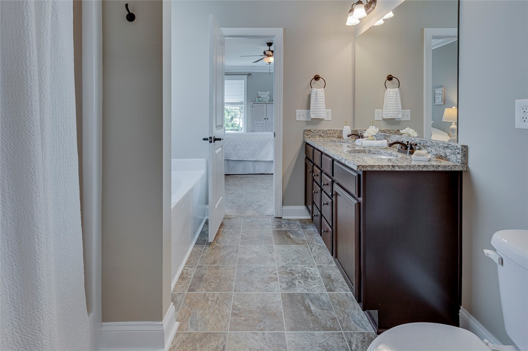 203 Streams Way Anderson, SC 29625 - Photo 12 of 47 This primary bathroom boasts a double vanity with granite counters and durable tile flooring.