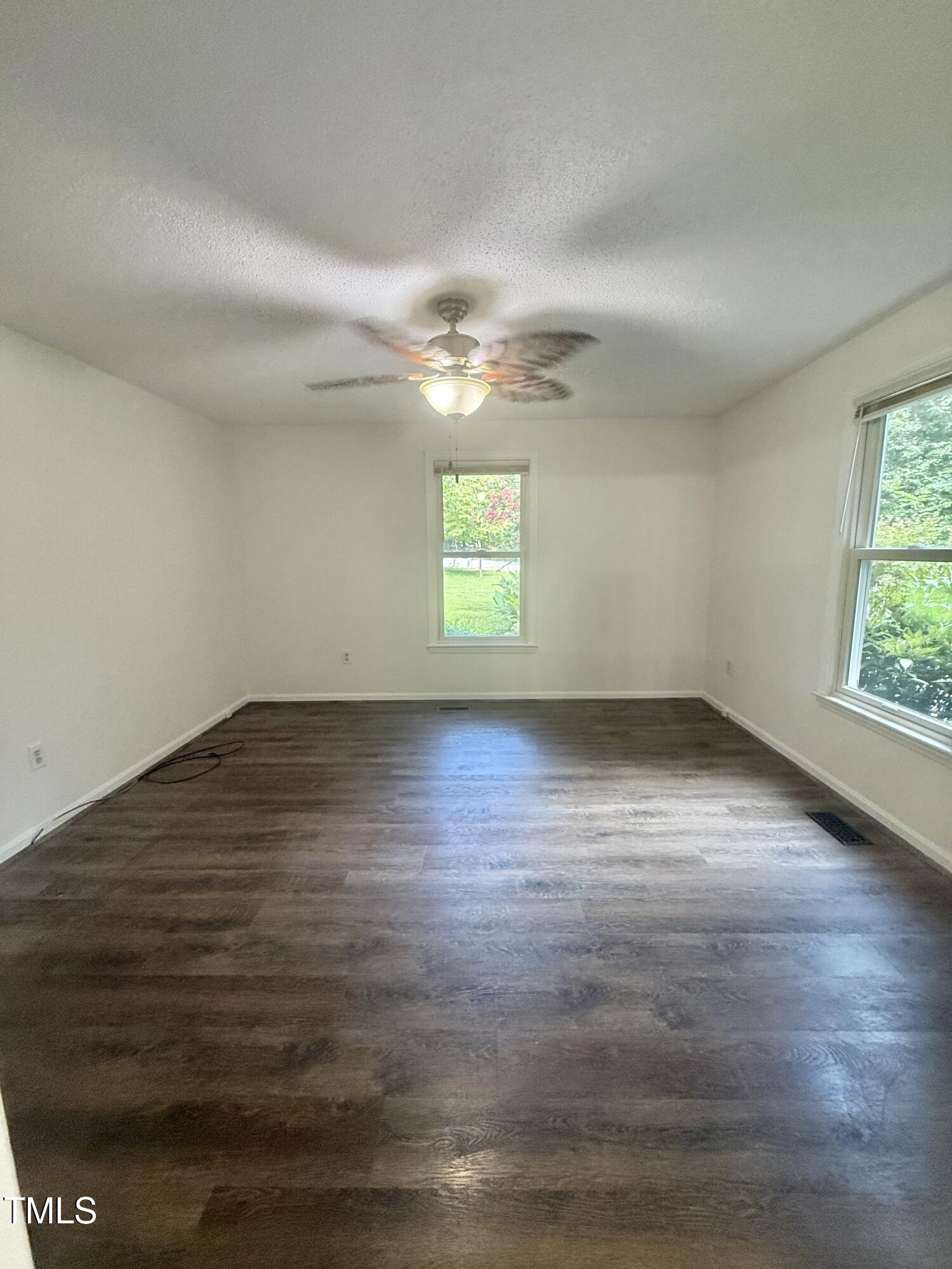 192 Misty Hollow Road Timberlake, NC 27583 - Photo 14 of 43 an empty room with wooden floor and windows
