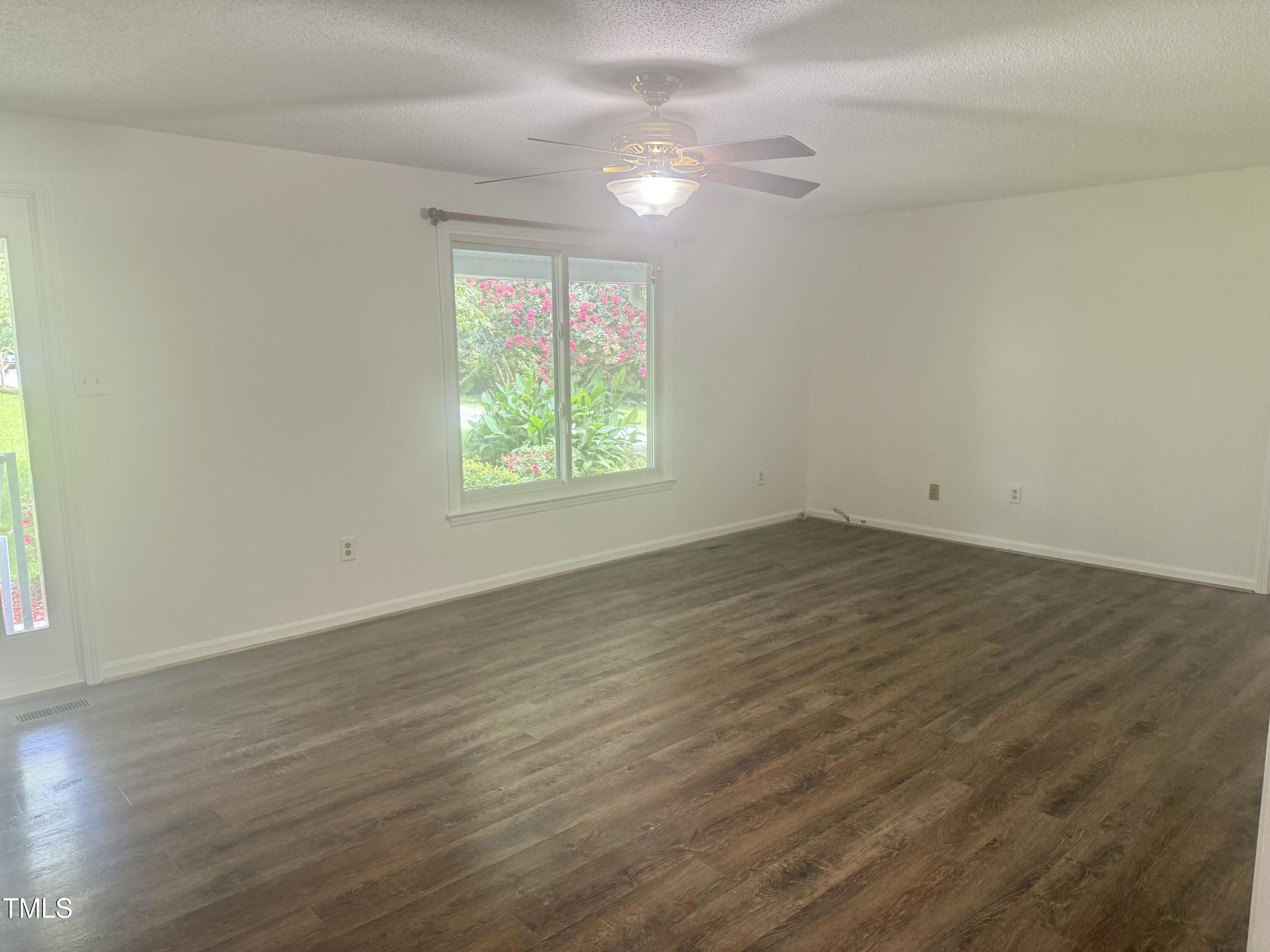 192 Misty Hollow Road Timberlake, NC 27583 - Photo 16 of 43 an empty room with wooden floor and windows