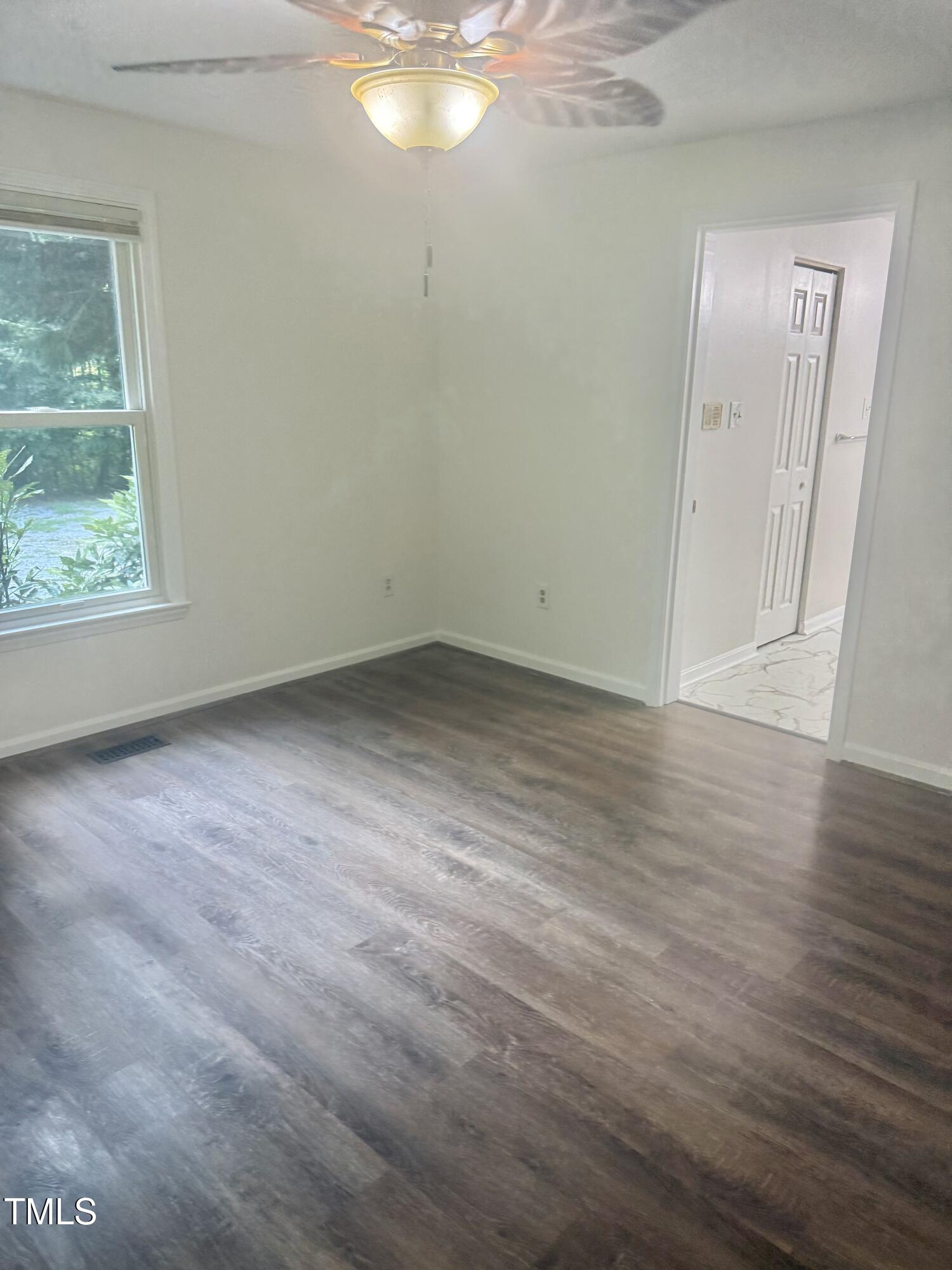 192 Misty Hollow Road Timberlake, NC 27583 - Photo 18 of 43 an empty room with wooden floor and windows