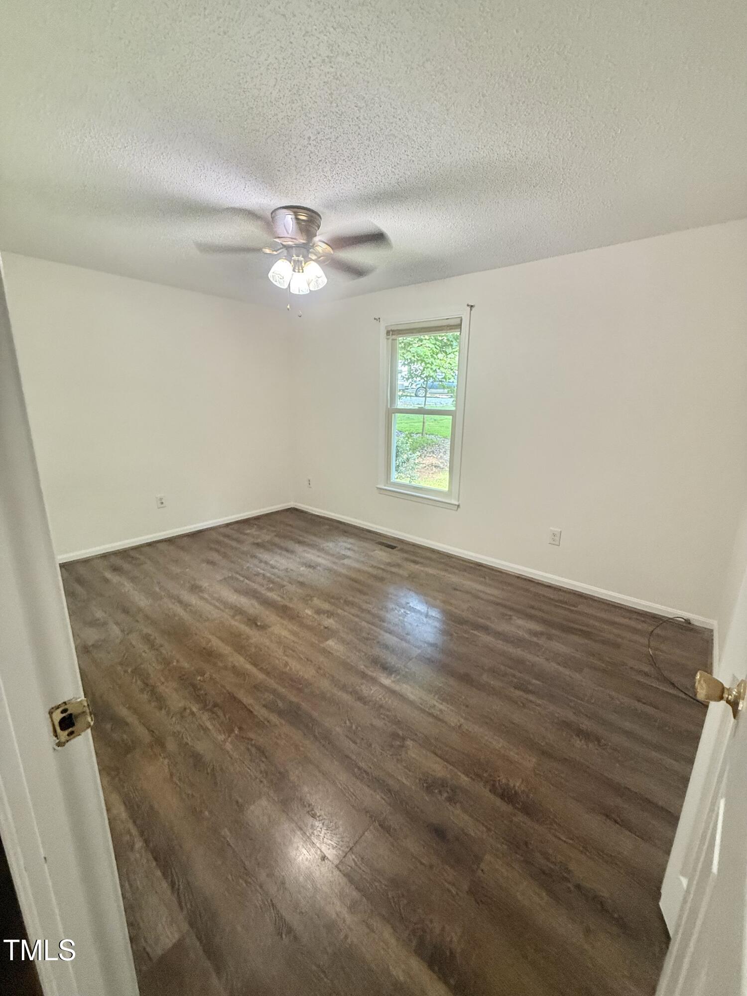 192 Misty Hollow Road Timberlake, NC 27583 - Photo 28 of 43 an empty room with wooden floor ceiling fan and windows