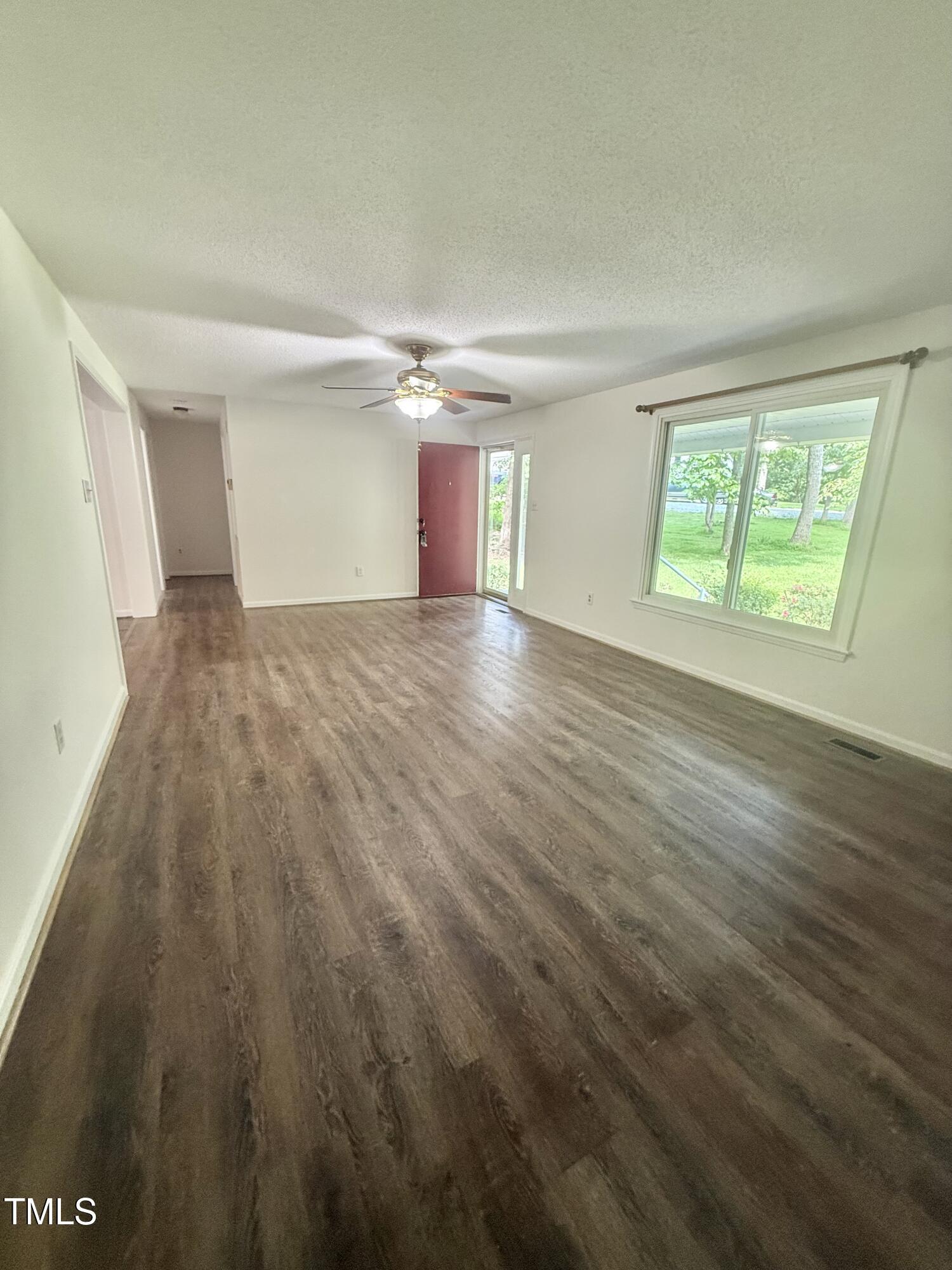 192 Misty Hollow Road Timberlake, NC 27583 - Photo 4 of 43 an empty room with wooden floor and windows