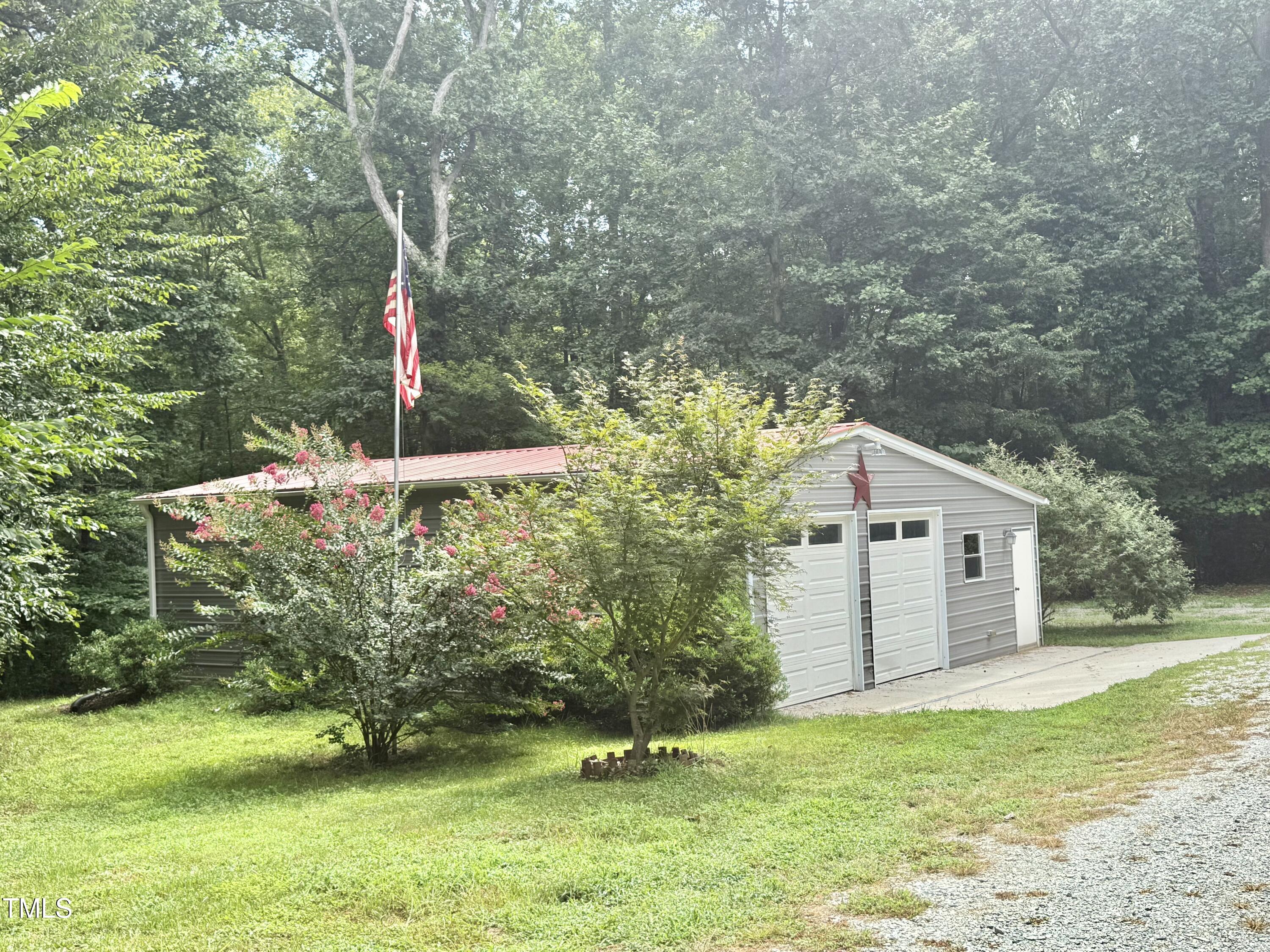 192 Misty Hollow Road Timberlake, NC 27583 - Photo 43 of 43 a backyard of a house with lots of green space and fountain