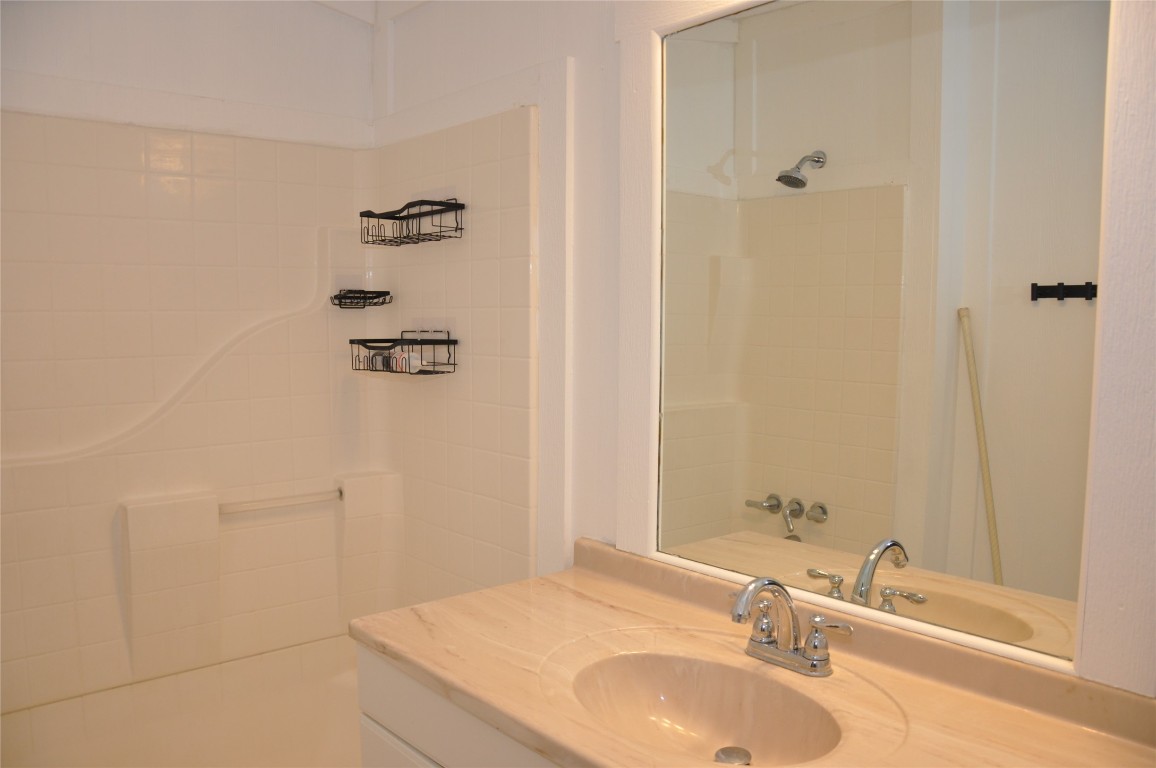 367 Mesquite Street Bertram, TX 78605 - Photo 14 of 23 a bathroom with a granite countertop sink a shower and a mirror