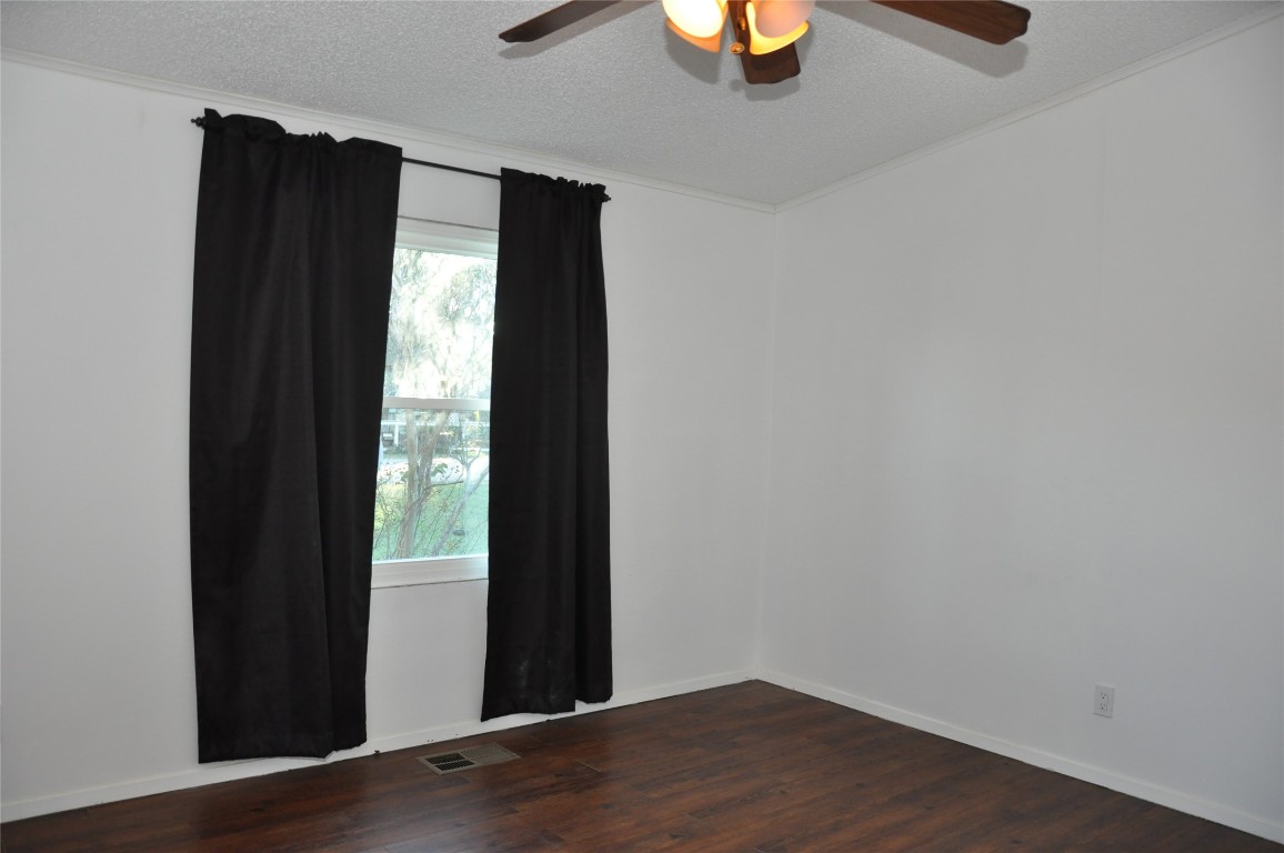 367 Mesquite Street Bertram, TX 78605 - Photo 18 of 23 a view of an empty room with wooden floor and a window