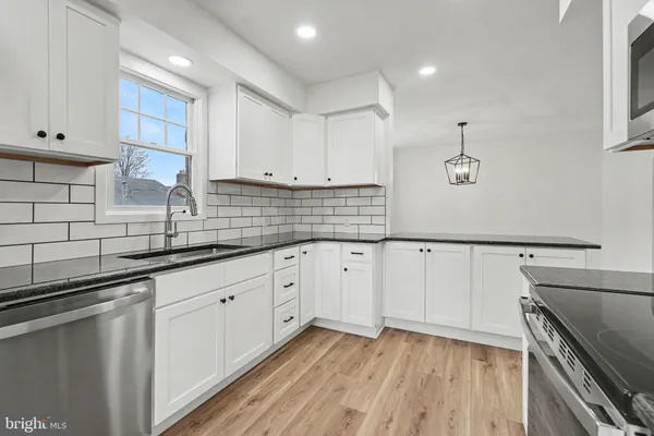a kitchen with granite countertop white cabinets and white appliances