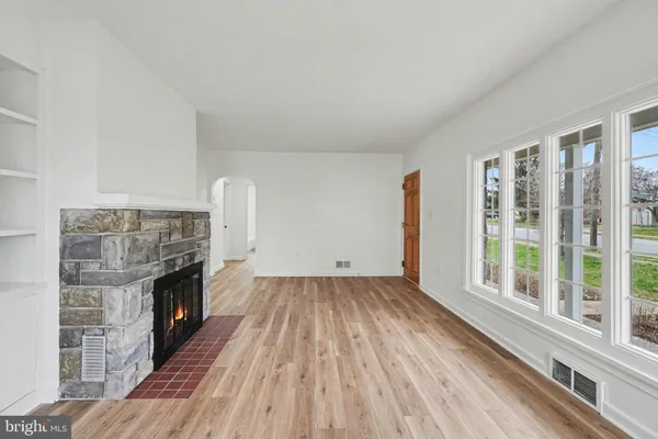 a view of empty room with wooden floor and fireplace