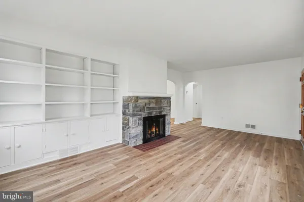 a view of a room with wooden floor and a fireplace