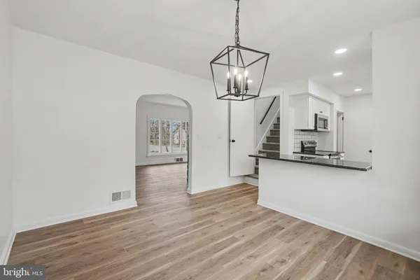 a view of a kitchen with wooden floor and a chandelier