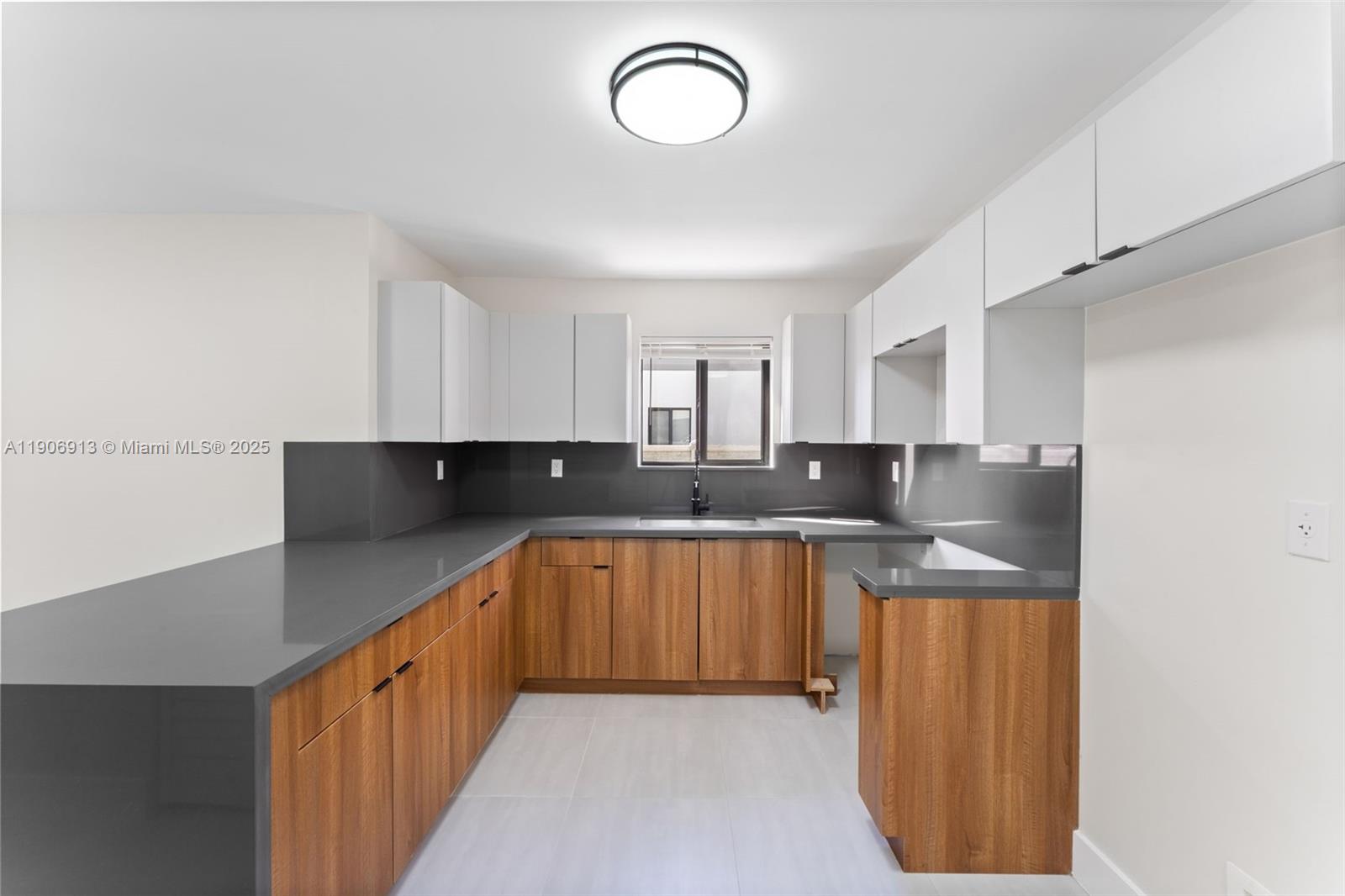 1171 Northwest 66th Street Miami, FL 33150 - Photo 24 of 34 a kitchen with stainless steel appliances granite countertop a sink and dishwasher a refrigerator with wooden cabinets