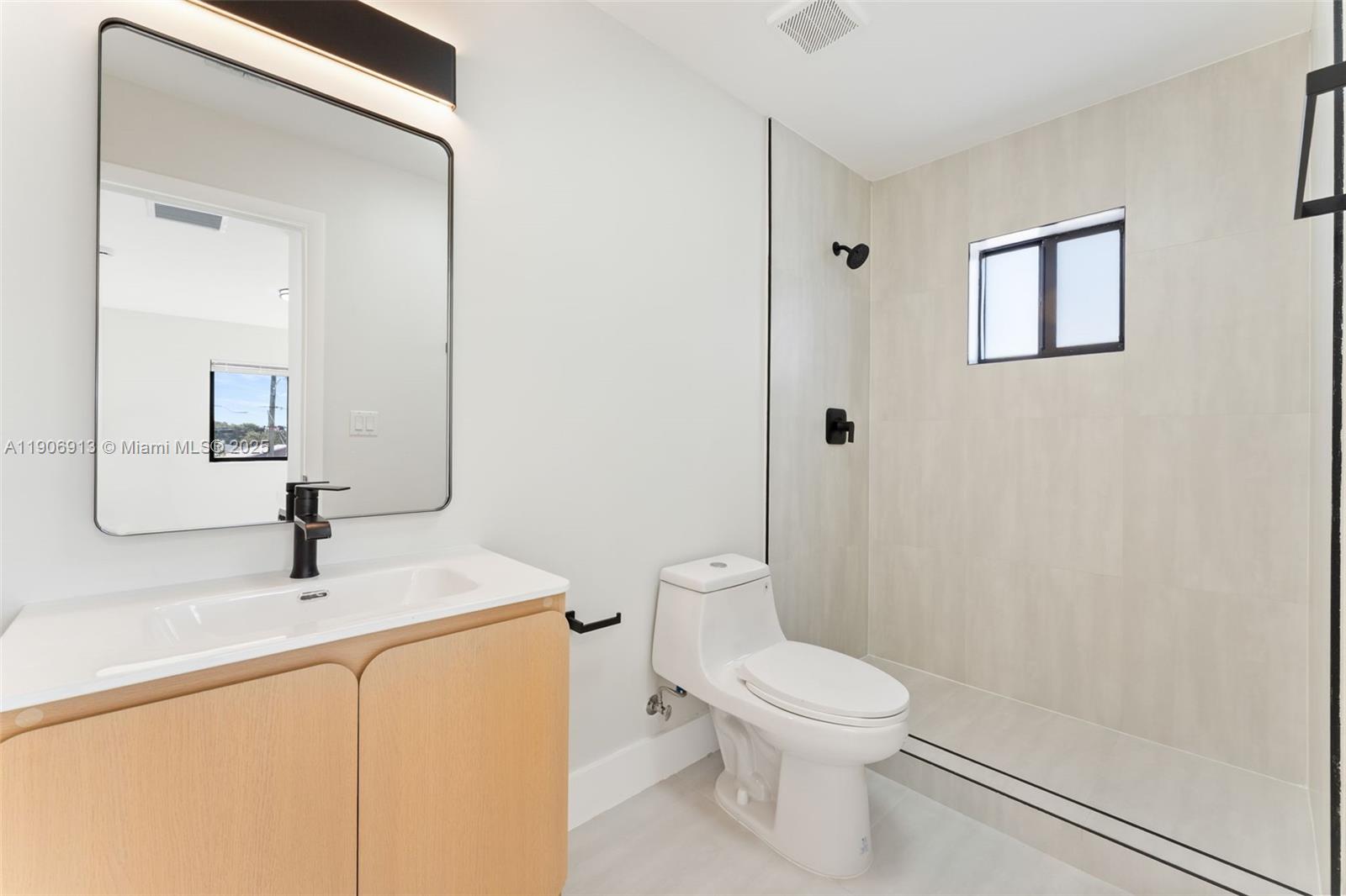 1171 Northwest 66th Street Miami, FL 33150 - Photo 32 of 34 a bathroom with a toilet a sink and mirror