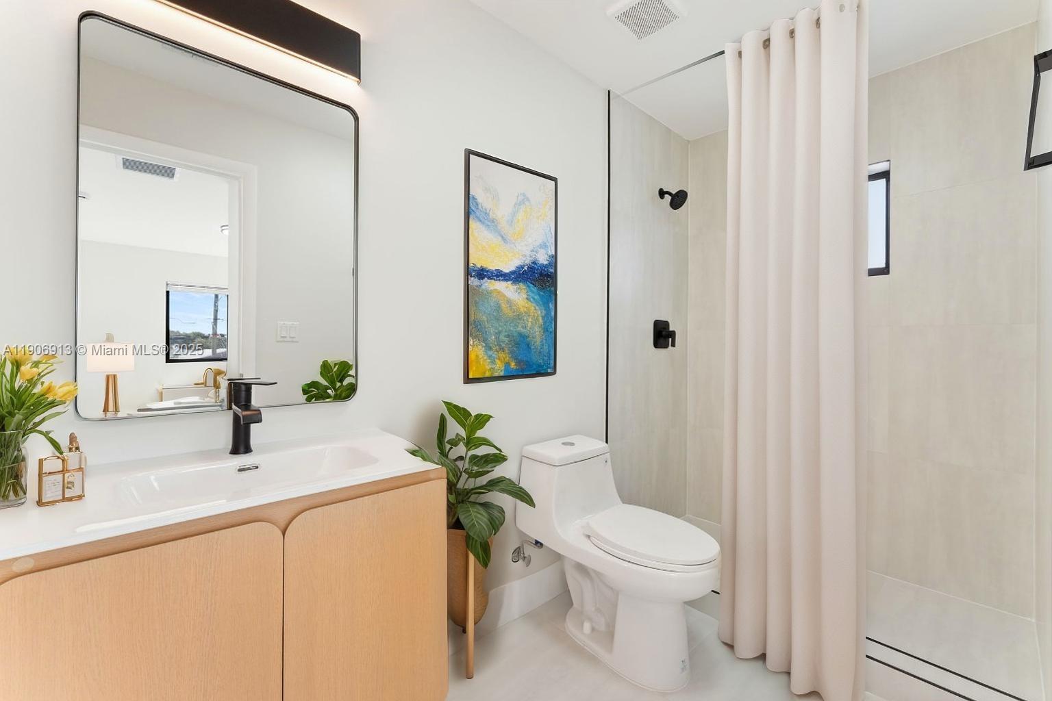 1171 Northwest 66th Street Miami, FL 33150 - Photo 9 of 34 a bathroom with a toilet a sink a mirror a vanity and shower