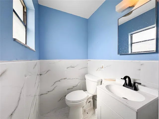a view of empty room with wooden floor and ceiling fan