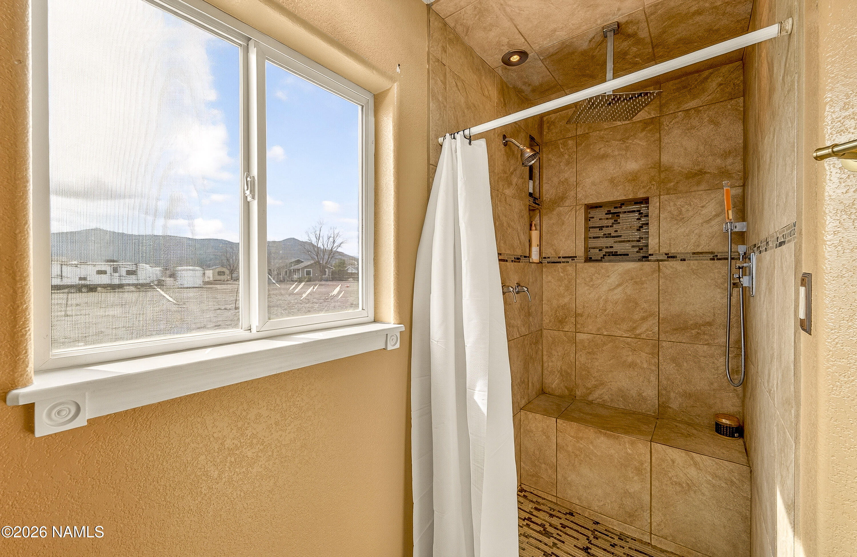 7725 Alma Road Flagstaff, AZ 86004 - Photo 19 of 38 a bathroom with a shower and a window