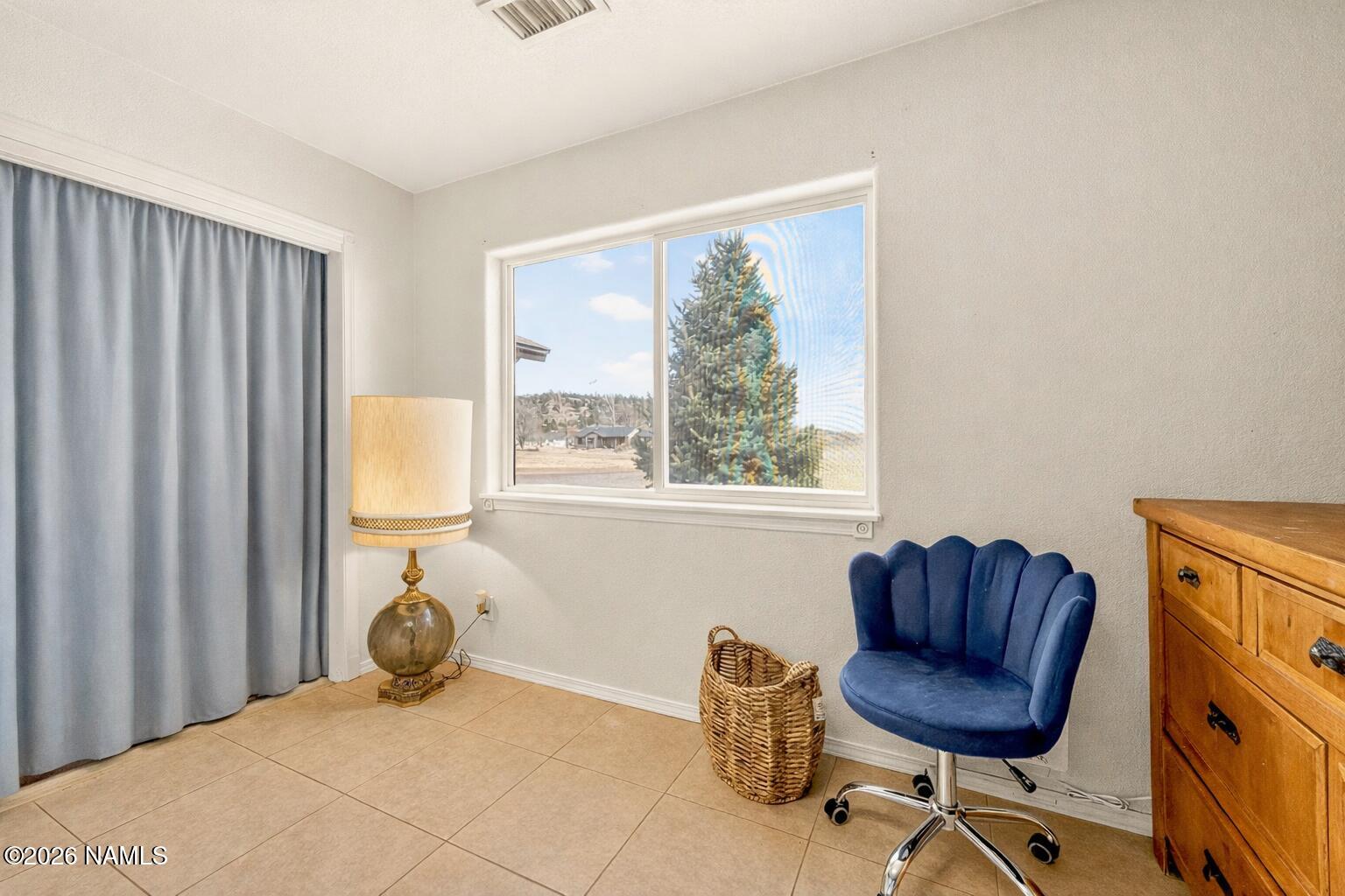 7725 Alma Road Flagstaff, AZ 86004 - Photo 23 of 38 a bedroom with a bed and chair