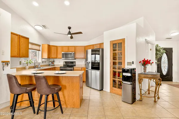 a kitchen with stainless steel appliances kitchen island granite countertop dining table chair and a refrigerator