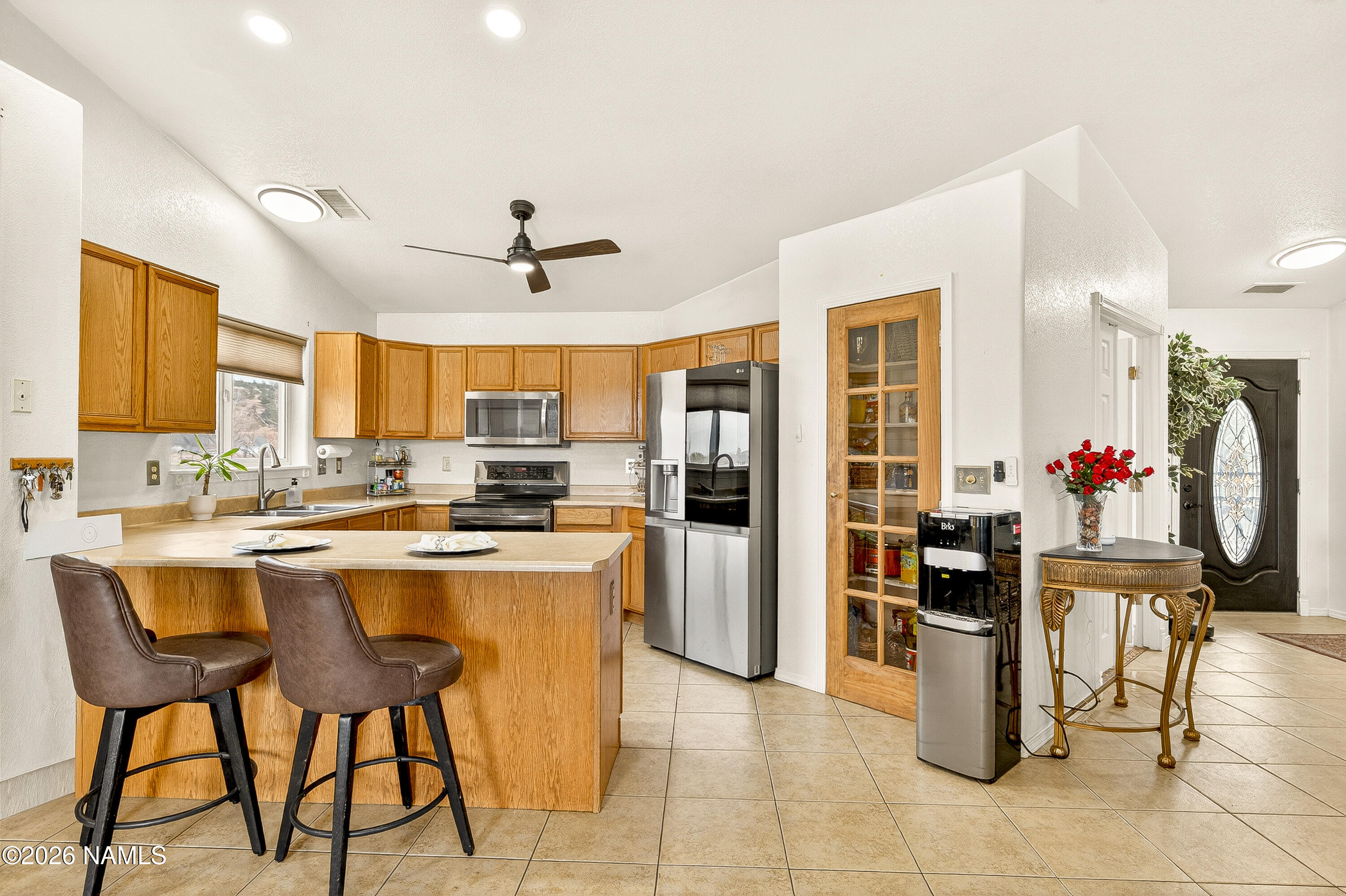 7725 Alma Road Flagstaff, AZ 86004 - Photo 7 of 38 a kitchen with stainless steel appliances kitchen island granite countertop dining table chair and a refrigerator