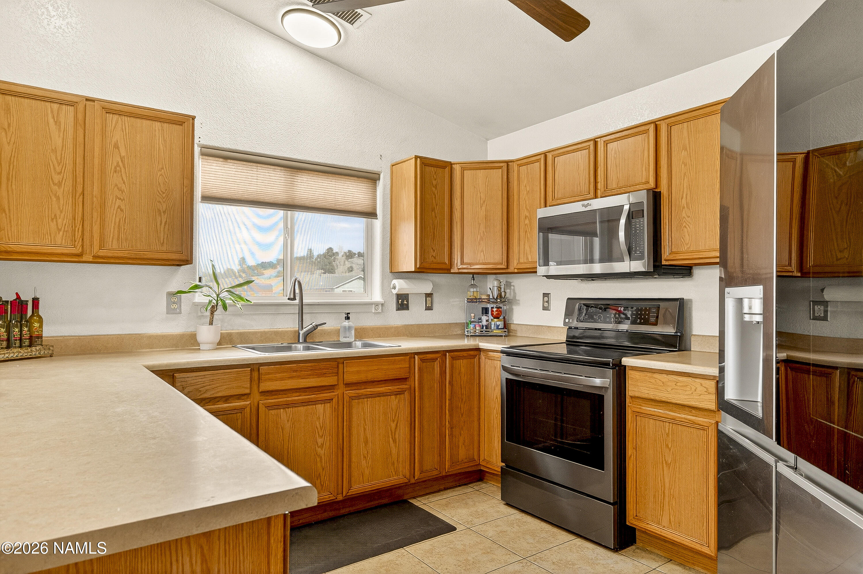 7725 Alma Road Flagstaff, AZ 86004 - Photo 9 of 38 a kitchen with stainless steel appliances a sink cabinets and a window