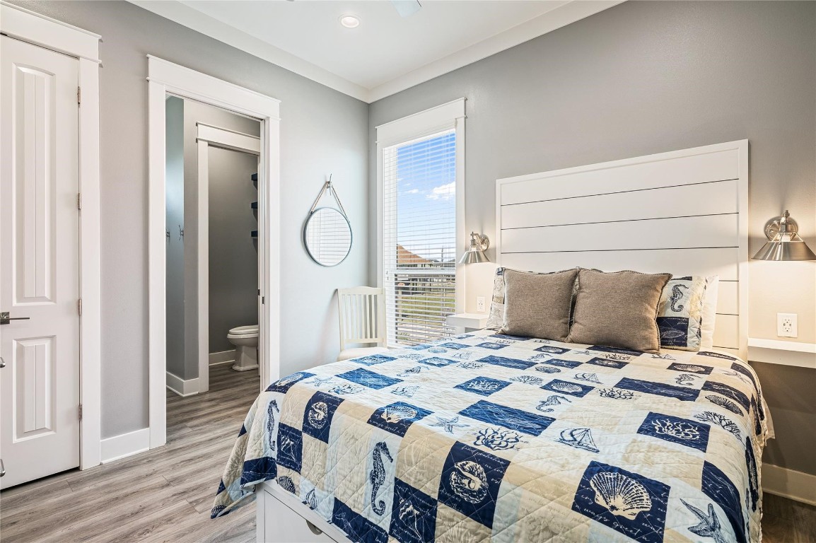2576 Whitecap Crystal Beach, TX 77650 - Photo 29 of 49 a bedroom with a bed and wooden floor