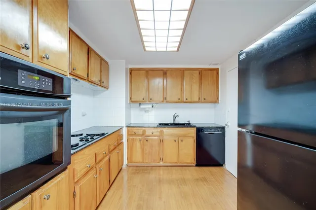 a kitchen with stainless steel appliances granite countertop a sink a stove cabinets and a window