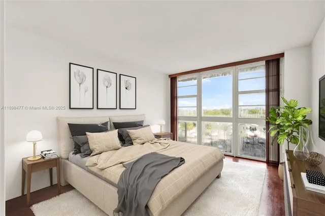 a bedroom with a large bed and a potted plant