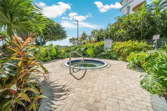 a view of a swimming pool with a yard and palm trees