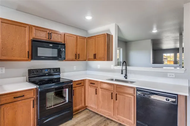 a large kitchen with stainless steel appliances kitchen island granite countertop a stove and a sink