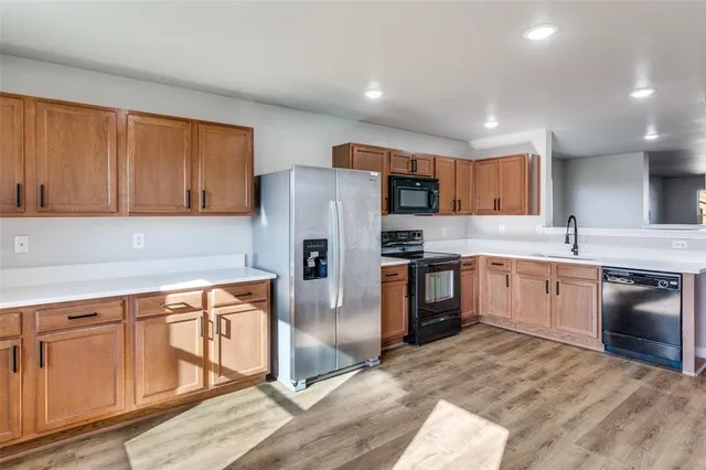 a kitchen with stainless steel appliances granite countertop a refrigerator sink and stove