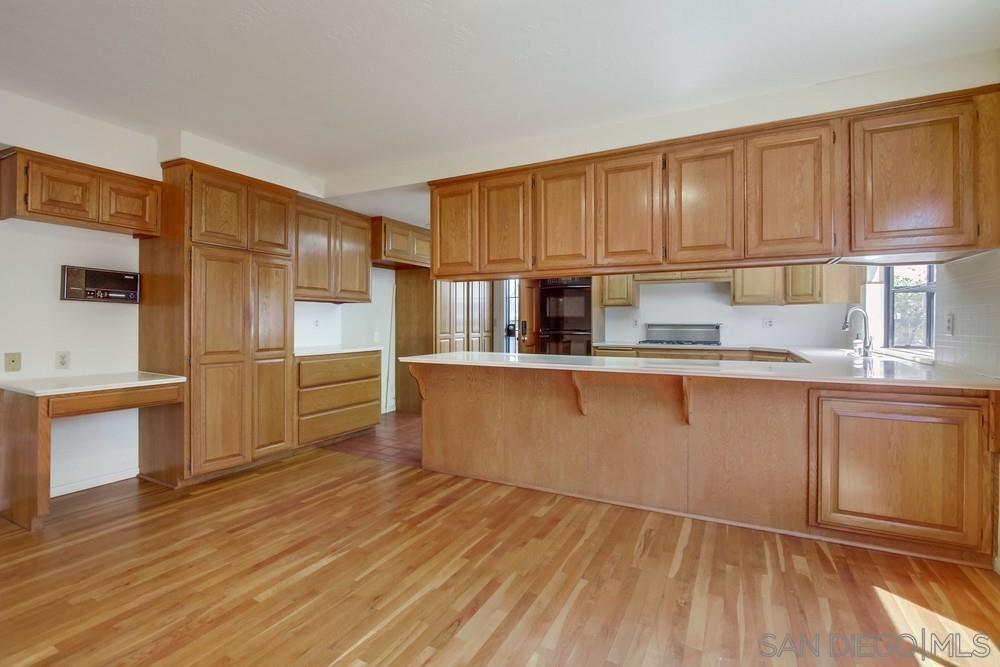 349 G Coronado, CA 92118 - Photo 7 of 18 a kitchen with granite countertop wooden floors stainless steel appliances and cabinets