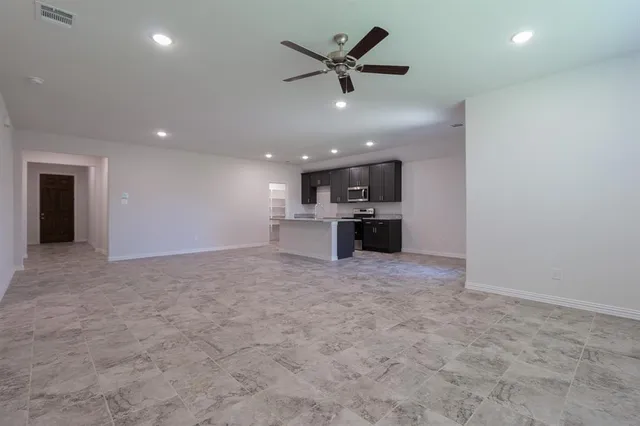a kitchen with kitchen island a counter top space a sink stainless steel appliances and cabinets