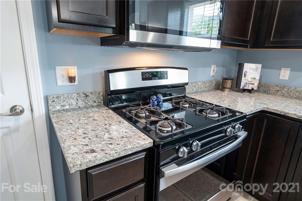 198 Alpine Ridge Drive Asheville, NC 28803 - Photo 9 of 24 a kitchen with a stove and a microwave
