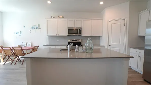 a kitchen with kitchen island a stove a sink and a refrigerator