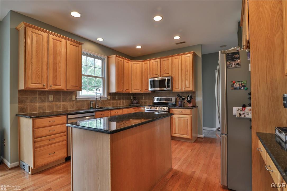 115 Kichline Road Hellertown, PA 18055 - Photo 9 of 45 a kitchen with stainless steel appliances granite countertop a refrigerator a sink dishwasher a stove and white countertops with wooden floor