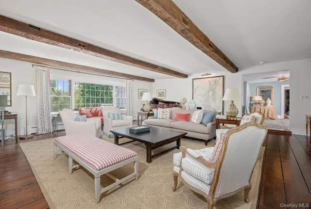a living room with furniture a table and wooden floor
