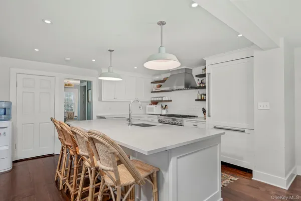 a kitchen with a table a refrigerator a stove a dining table and chairs with wooden floor