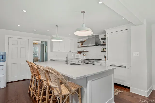 a kitchen with a table a refrigerator a stove a dining table and chairs with wooden floor