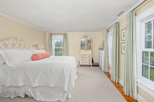 a bedroom with a bed and a large window