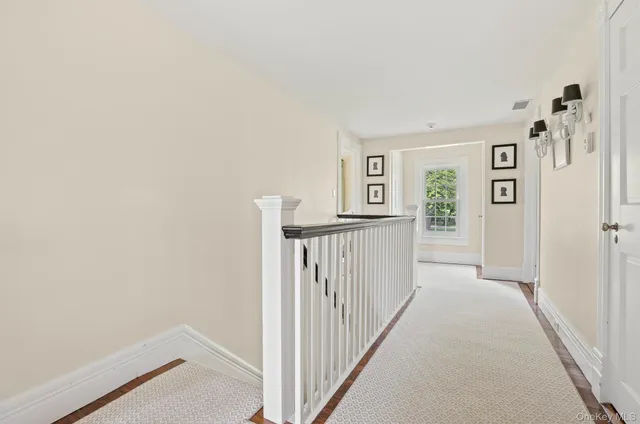a view of a hallway with white walls and stairs