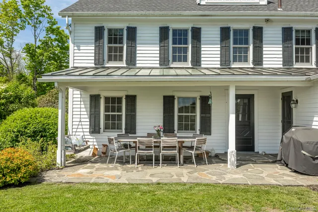 a view of a house with a chairs and table in a patio