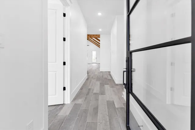 a view of a hallway with wooden floor and staircase