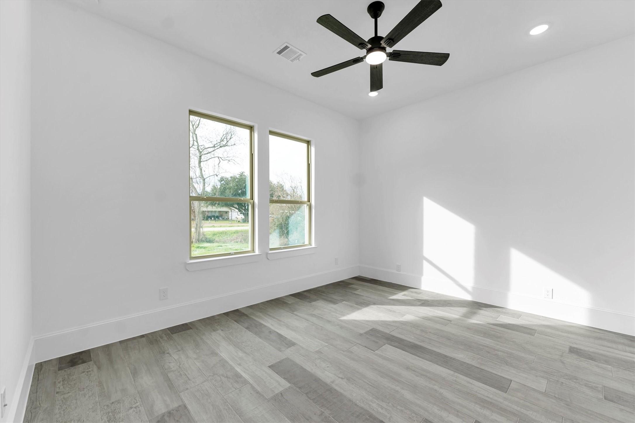 610 Sharon Street Prairie View, TX 77484 - Photo 37 of 42 an empty room with wooden floor fan and windows