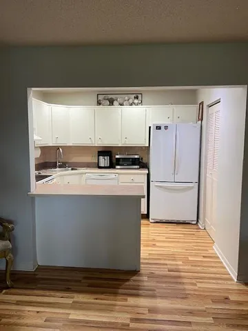 a view of kitchen with stainless steel appliances wooden floor