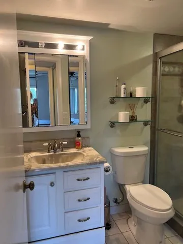a bathroom with a granite countertop toilet sink and mirror