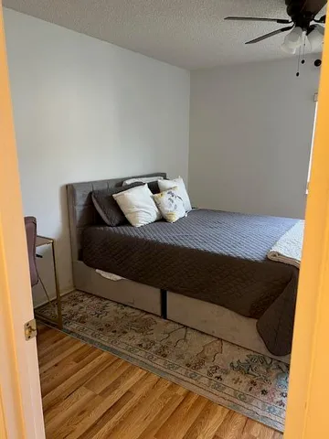 a bedroom with a bed and wooden floor