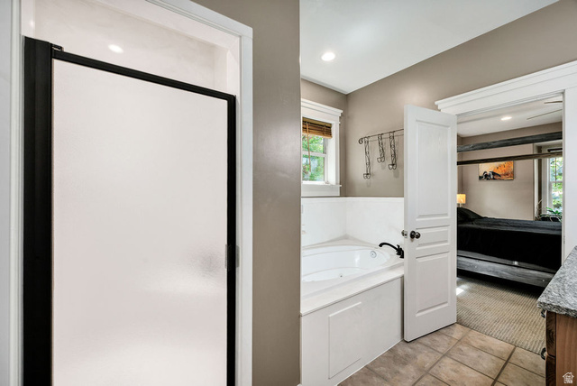 288 525 South Providence, UT 84332 - Photo 19 of 71 Frosted glass shower enclosure with black trim, corner jetted tub, tile flooring, and a window with blinds