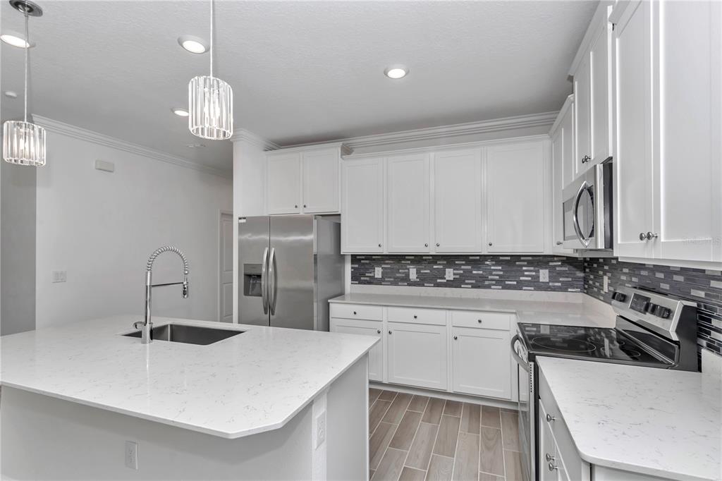 7867 Southwest 74th Loop Ocala, FL 34481 - Photo 15 of 55 a kitchen with a sink a stove and chairs