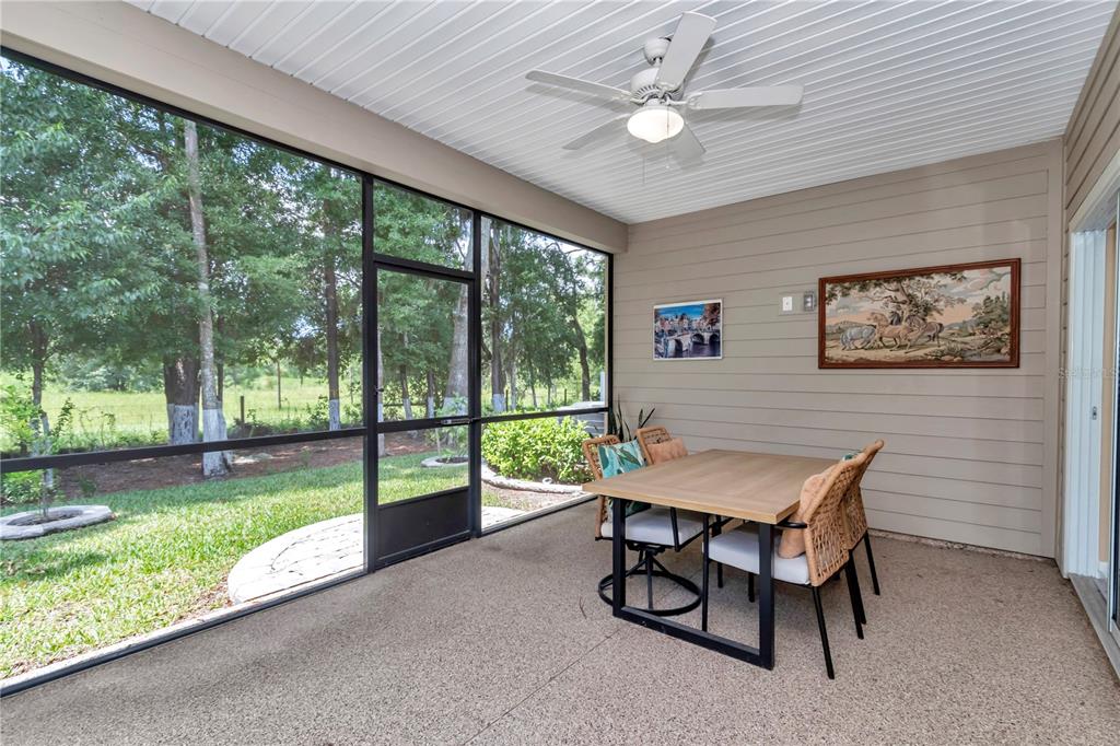 7867 Southwest 74th Loop Ocala, FL 34481 - Photo 20 of 55 a dining room with wooden floor and a floor to ceiling window