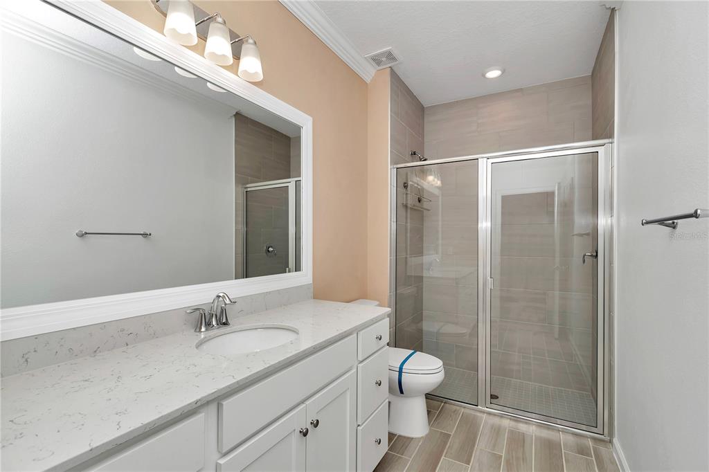 7867 Southwest 74th Loop Ocala, FL 34481 - Photo 27 of 55 a bathroom with a granite countertop sink toilet a shower and a mirror