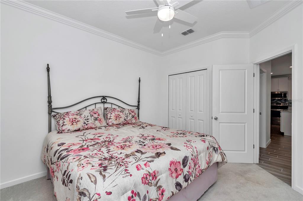 7867 Southwest 74th Loop Ocala, FL 34481 - Photo 32 of 55 a bedroom with a large bed and a chandelier