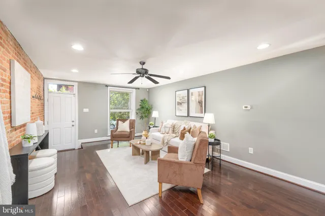 a living room with furniture wooden floor and a large window